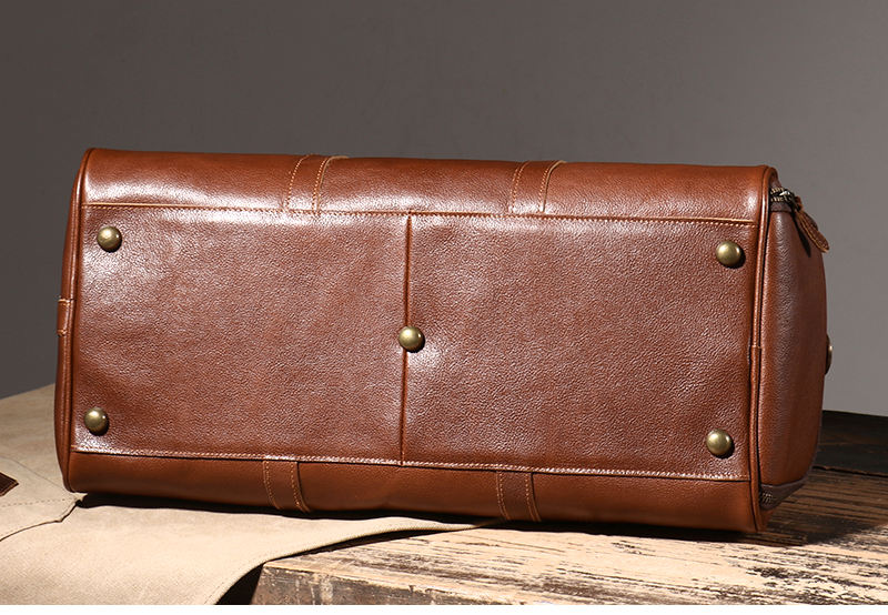 Brown leather weekender bag base with protective brass feet